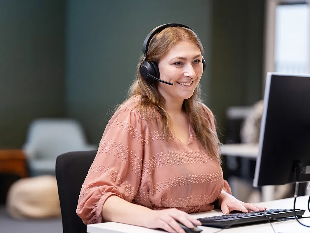 Vrouwelijke MCC medewerker achter computer met headset op
